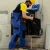 serviceman-using-drill-to-fix-condenser-2025-02-19-22-52-43-utc