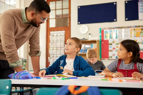 teacher-helping-primary-students-with-homework-2024-07-10-00-50-07-utc